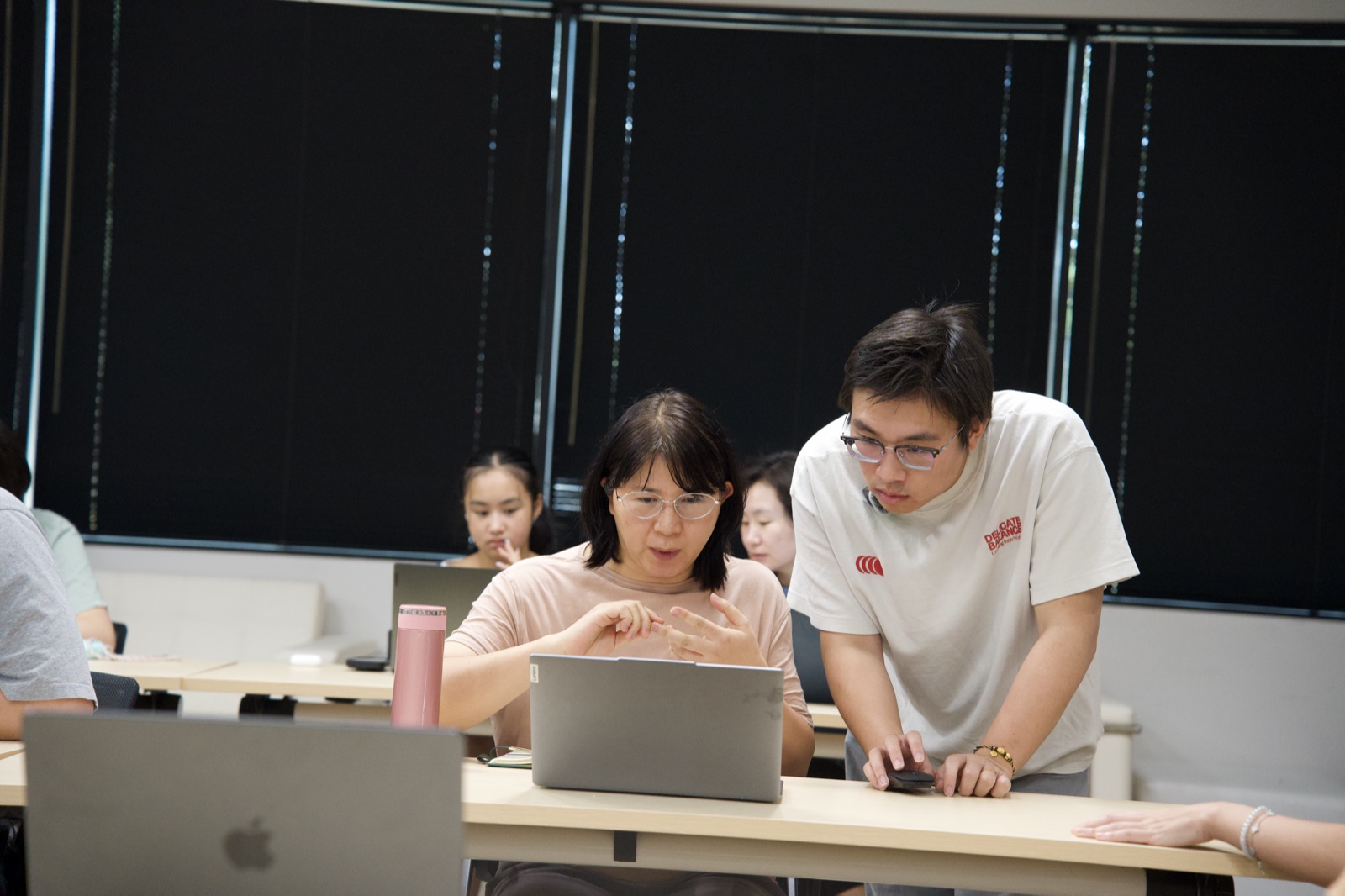Quandong helping an attendee at her laptop during the build session